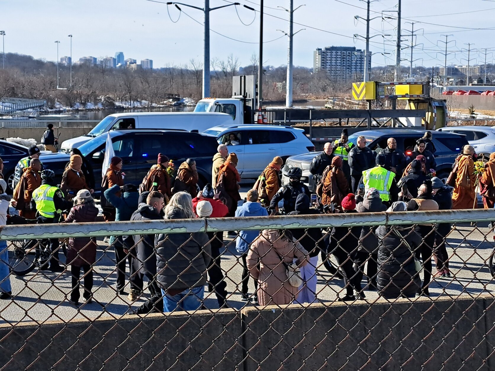 People pass flowers to the monks as they walk past Potomac Yard on Feb. 9, 2026.