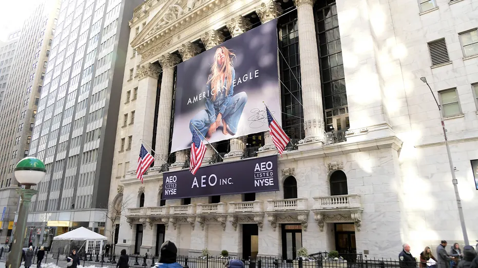 A large outdoor advertisement featuring actress Sydney Sweeney is displayed near a major financial landmark in Manhattan.