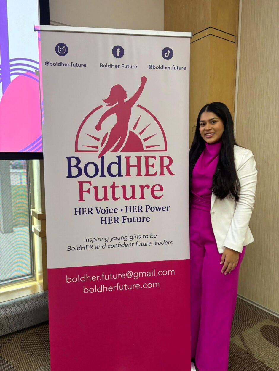 Karishma Sharma stands with poster that says boldher future