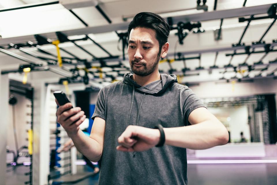 japanese man checking smart phone and smart watch